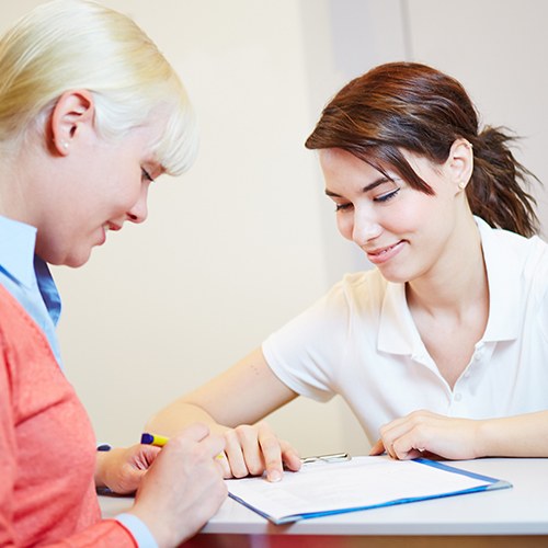 Dentistry team member and patient reviewing dental insurance paperwork