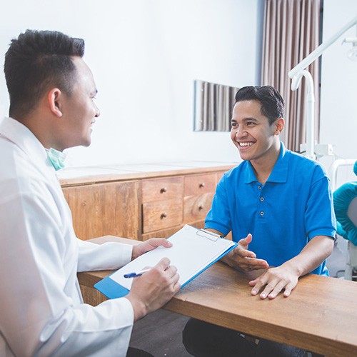 dentist and patient talking over the paperwork