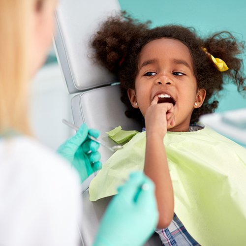 Child pointing to smile after dental sealant treatment