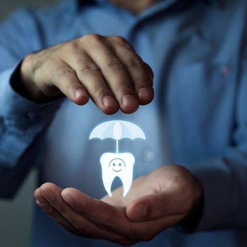 a person covering a tooth and umbrella for dental insurance