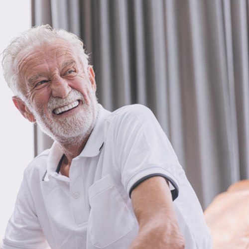 Senior man sitting on a couch smiling