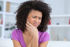 Woman with toothache holding cheek