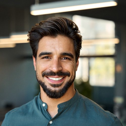 Bearded man in button-up shirt smiling