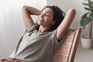 Woman leaning back in chair and resting at home