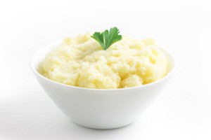 Bowl of mashed potatoes and sprig of parsley