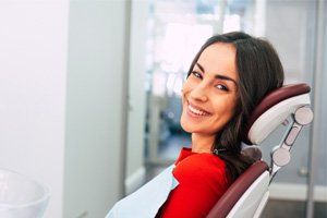 Female patient in red shirt smiling in dental chair