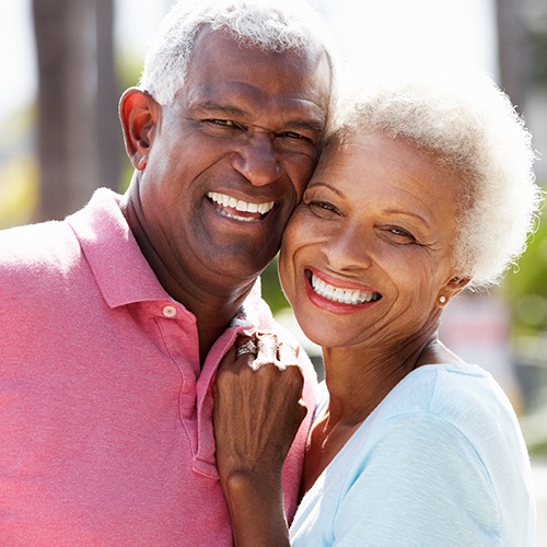 Man and woman enjoying the benefits of dental implants