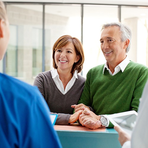 Man and woman discussing the cost of dental implants with dentist