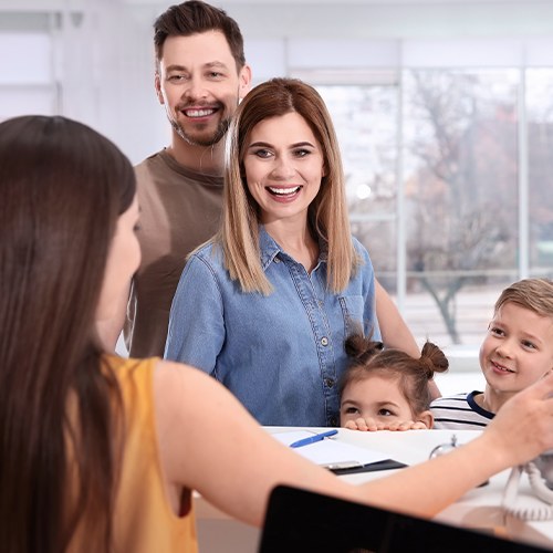 Family of three turning in dental insurance forms