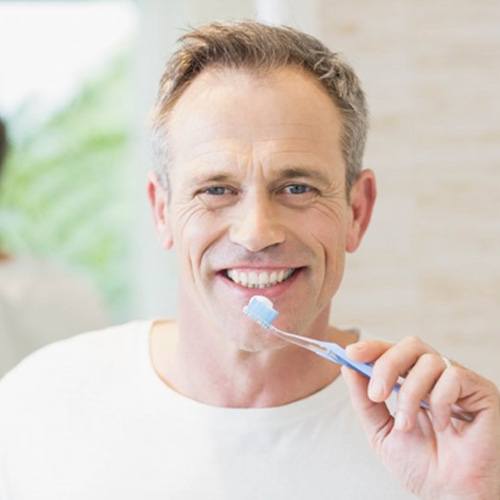 a man preparing to brush his dental implants