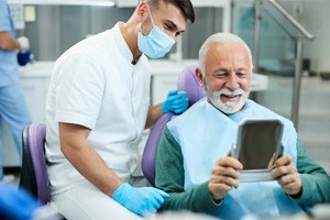 a patient smiling after receiving his dental implants