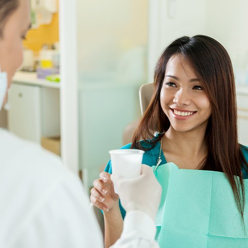 Woman smiling at dentist during preventive dentistry checkup and teeth cleaning visit