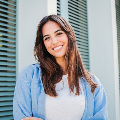 Woman with white teeth smiling while standing outside