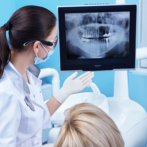 Dentist and dental patient looking at all digital x rays