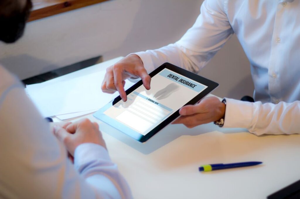 A man with a tablet showing a dental insurance plan.